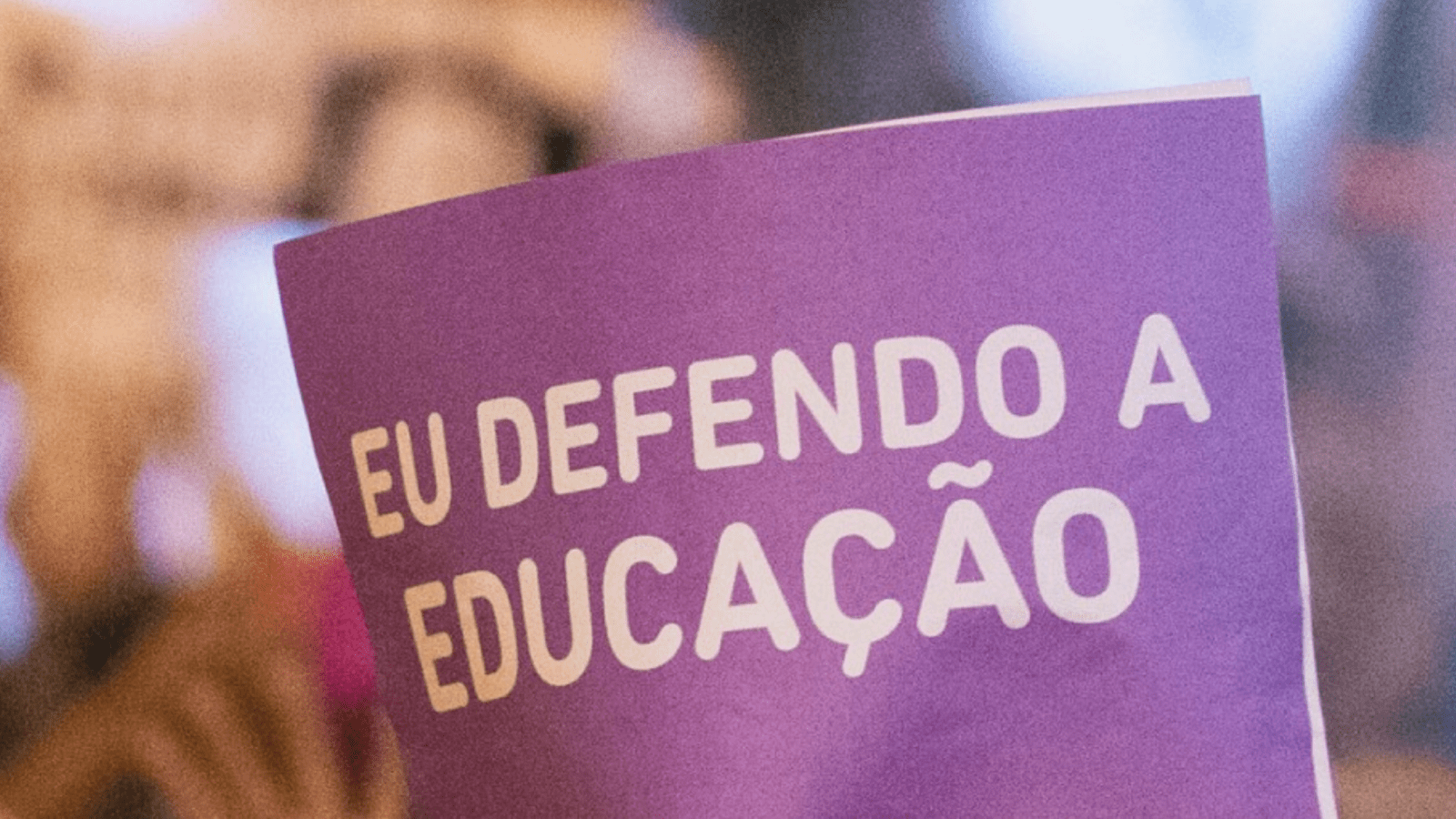 cartaz roxo com as palavras "eu defendo a educação"em branco